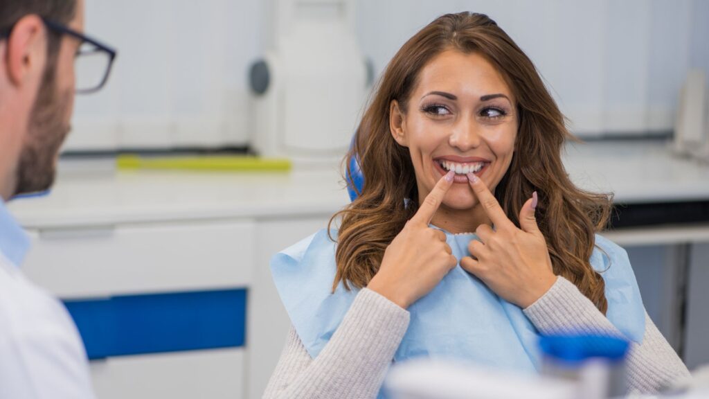 A woman smiling at her teeth with dental implants.