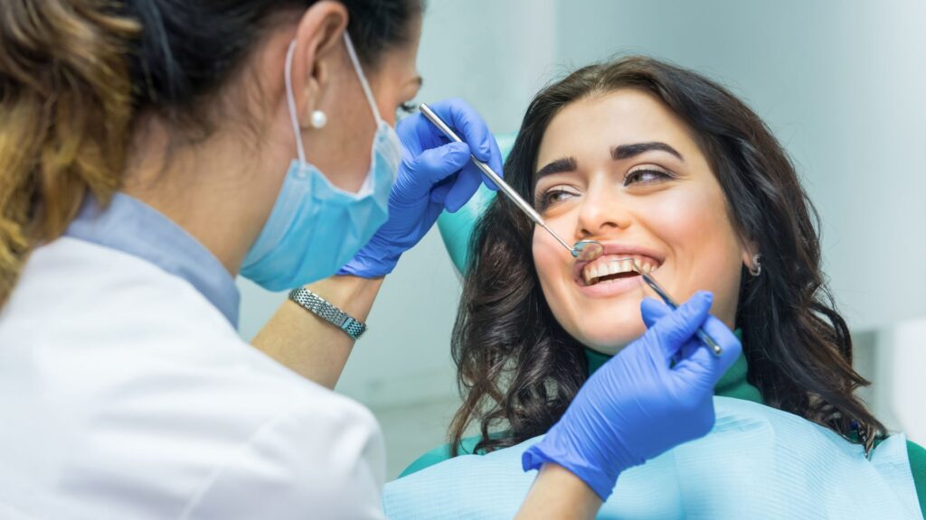 A dentist examining a patient's teeth at a family dental clinic.